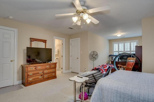 bedroom with light colored carpet, ceiling fan, and connected bathroom