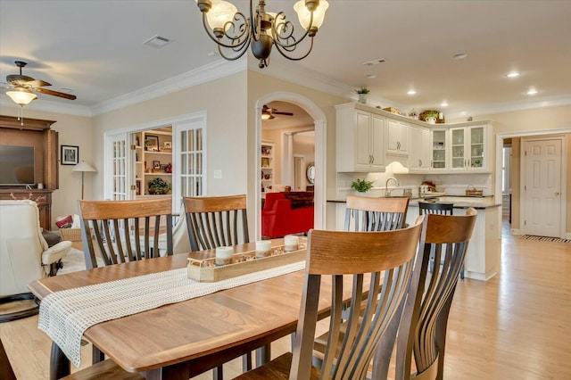 dining room featuring light hardwood / wood-style floors, crown molding, and sink