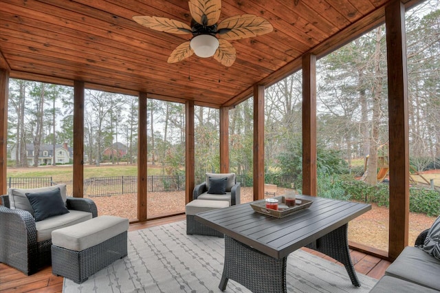 sunroom featuring lofted ceiling, ceiling fan, and wooden ceiling