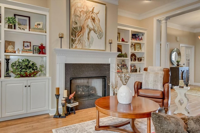 living area with light hardwood / wood-style floors, crown molding, and built in features