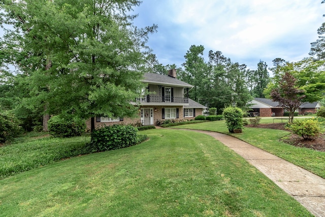3247 Ramsgate Rd, Augusta, GA 30909 - view of front of home with a front yard, a chimney, brick siding, and a balcony