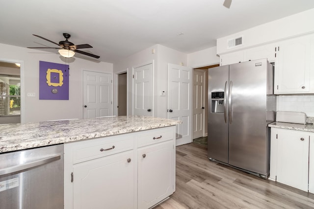 3247 Ramsgate Rd, Augusta, GA 30909 - kitchen featuring appliances with stainless steel finishes, a ceiling fan, light wood-type flooring, white cabinets, and decorative backsplash