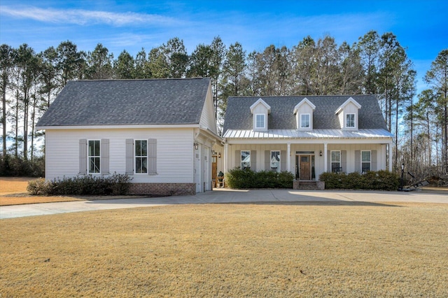 cape cod house featuring covered porch and a front yard