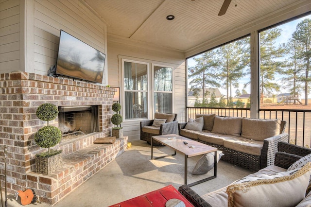 sunroom / solarium featuring wooden ceiling, ceiling fan, and an outdoor brick fireplace