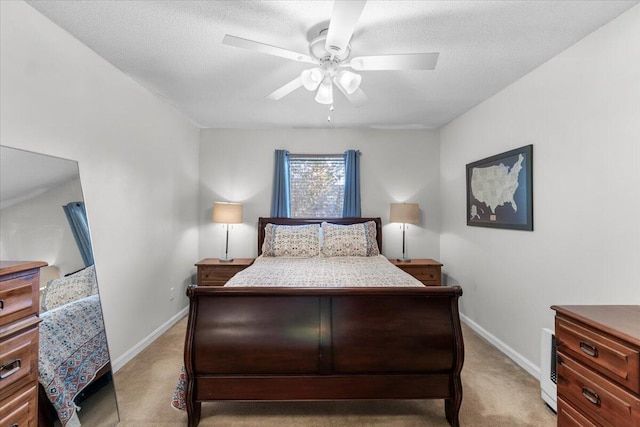 bedroom featuring a textured ceiling, ceiling fan, and light carpet