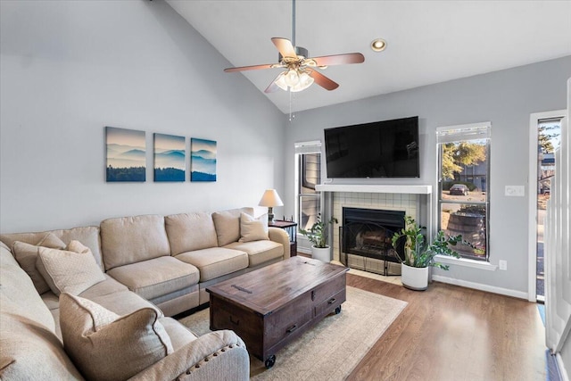 living room featuring a fireplace, wood-type flooring, ceiling fan, and lofted ceiling