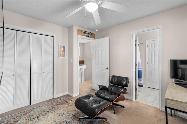 sitting room with ceiling fan and light carpet