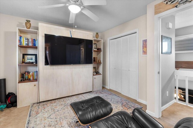 carpeted living room featuring ceiling fan