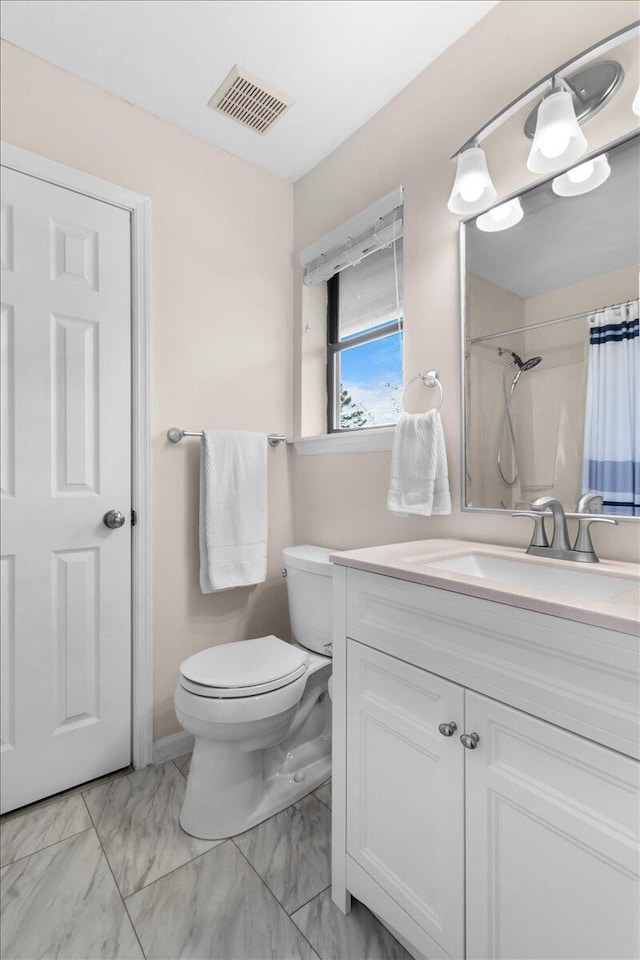 bathroom with vanity, toilet, and walk in shower