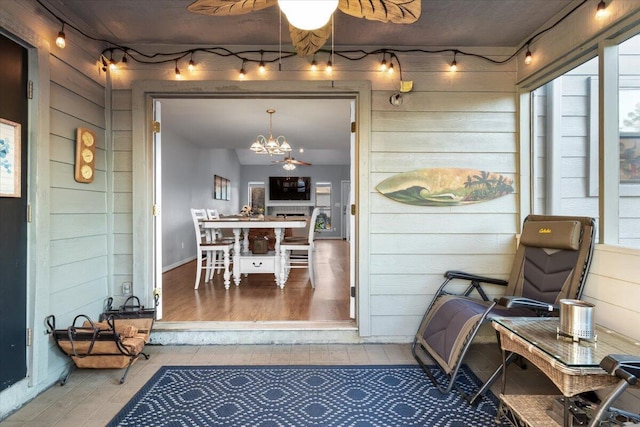 sunroom with ceiling fan with notable chandelier