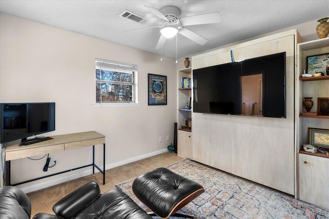 carpeted living room with ceiling fan and a textured ceiling