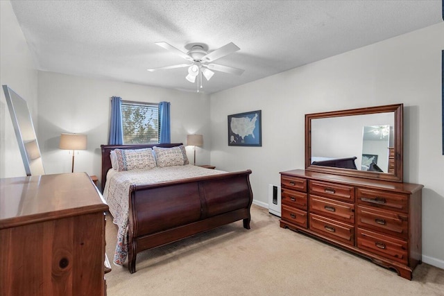 carpeted bedroom with ceiling fan and a textured ceiling