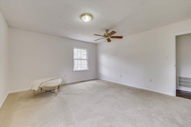 unfurnished room with carpet, visible vents, and baseboards