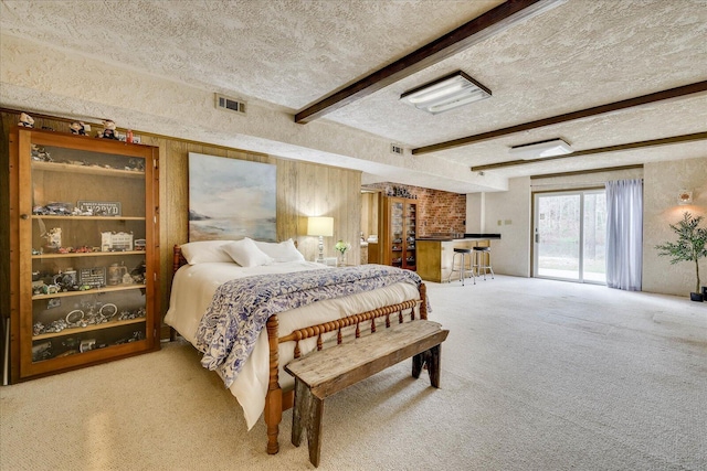 bedroom featuring visible vents, beam ceiling, a textured ceiling, carpet, and access to exterior