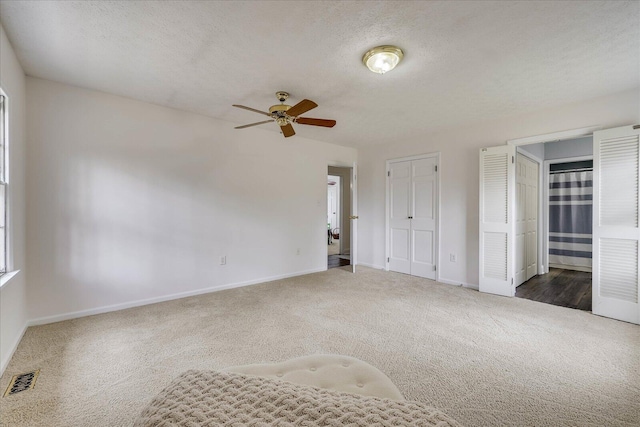 unfurnished bedroom featuring visible vents, baseboards, carpet, and a textured ceiling