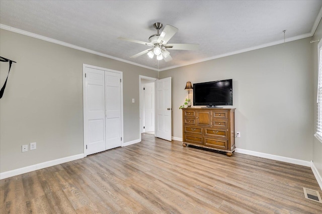 unfurnished bedroom with visible vents, crown molding, baseboards, and wood finished floors