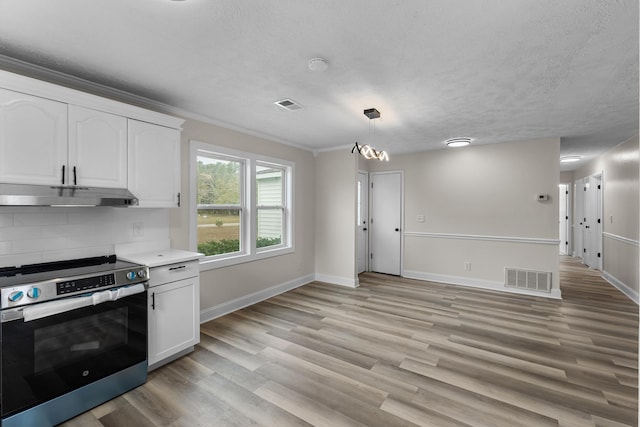 kitchen featuring an inviting chandelier, white cabinets, tasteful backsplash, decorative light fixtures, and stainless steel range oven