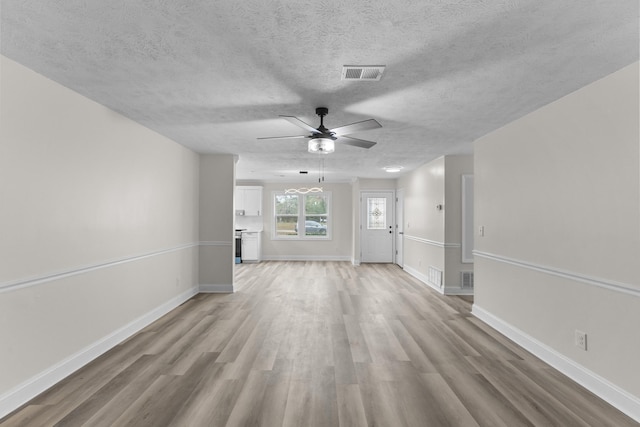 unfurnished living room with a textured ceiling, light hardwood / wood-style flooring, and ceiling fan