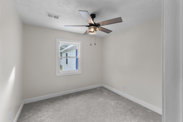 empty room with ceiling fan, carpet, and a textured ceiling