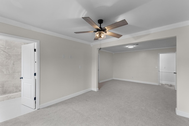 spare room featuring light carpet, ceiling fan, and crown molding