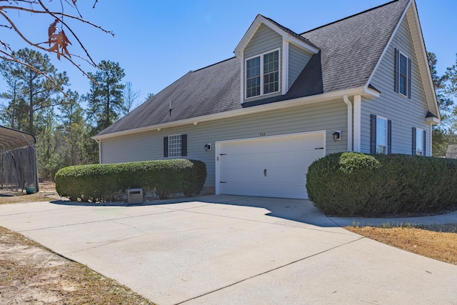 view of side of property featuring driveway, a shingled roof, and a garage