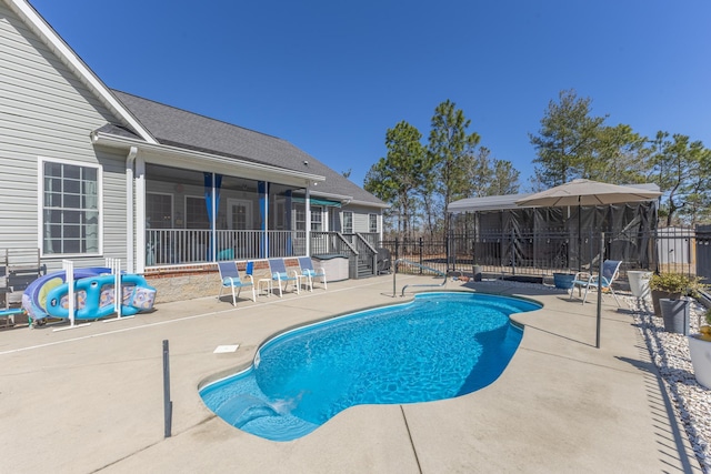 view of swimming pool with a fenced in pool, fence, a patio, and a sunroom