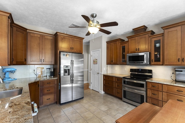 kitchen featuring brown cabinetry, stainless steel appliances, and a sink