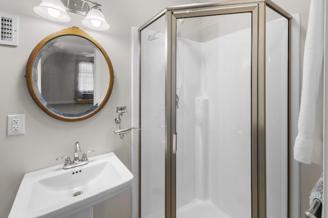 bathroom with a sink, visible vents, and a stall shower