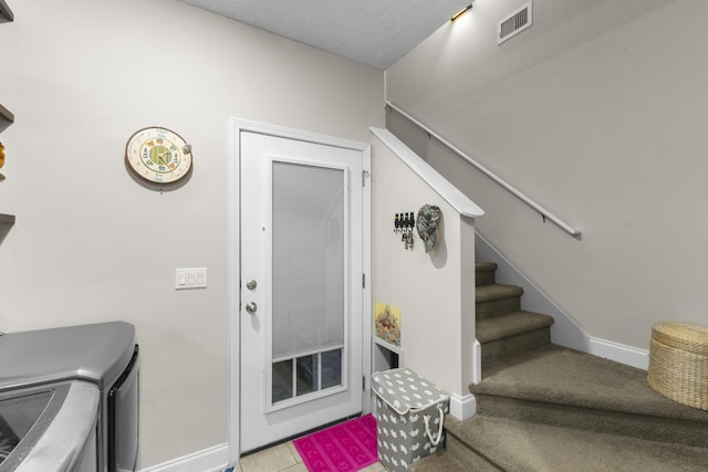 clothes washing area featuring visible vents, baseboards, washing machine and dryer, laundry area, and a textured ceiling