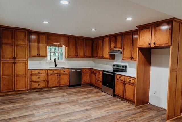 8643 Underwood Rd, Mitchell, GA 30820 - kitchen featuring stainless steel appliances, a sink, light wood-type flooring, brown cabinetry, and light countertops