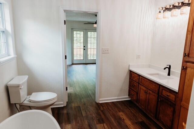 8643 Underwood Rd, Mitchell, GA 30820 - bathroom featuring wood finished floors, french doors, toilet, vanity, and baseboards