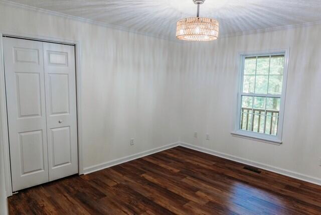 8643 Underwood Rd, Mitchell, GA 30820 - empty room with baseboards, a chandelier, dark wood-style floors, and ornamental molding