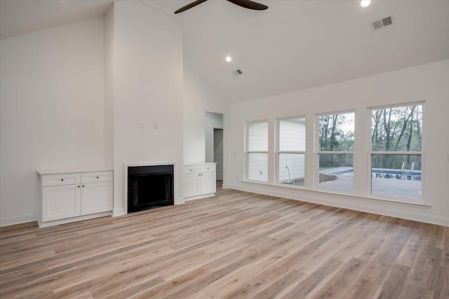 unfurnished living room with ceiling fan, high vaulted ceiling, and light hardwood / wood-style flooring