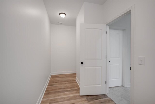 corridor with light hardwood / wood-style floors