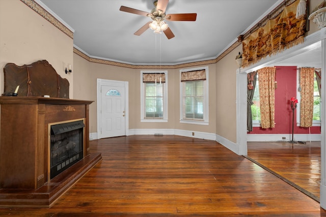 unfurnished living room with crown molding, dark hardwood / wood-style flooring, and ceiling fan