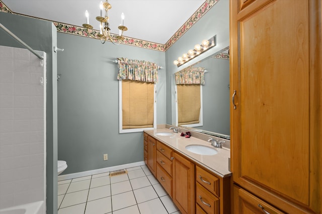 bathroom with tile patterned flooring, vanity, toilet, and a notable chandelier