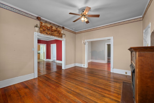 unfurnished living room featuring ceiling fan, dark hardwood / wood-style floors, and ornamental molding