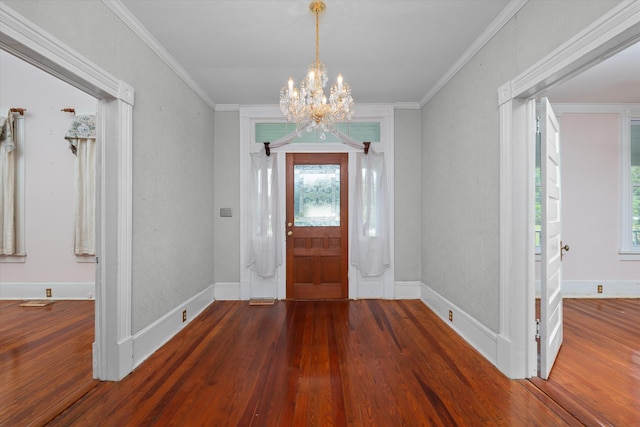 entrance foyer with ornamental molding, dark wood-type flooring, and an inviting chandelier