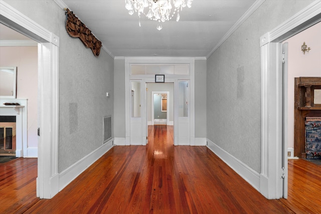 corridor featuring hardwood / wood-style floors, a notable chandelier, and crown molding