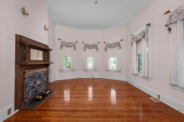 interior space with plenty of natural light, wood-type flooring, and ornamental molding