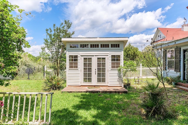 view of outbuilding with french doors and a lawn