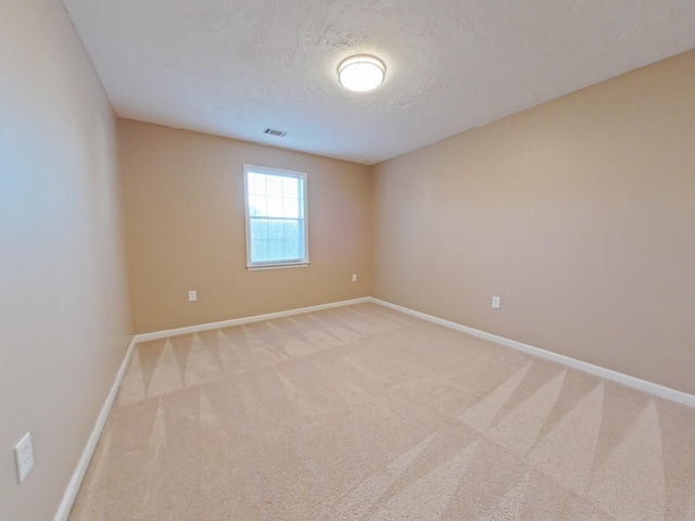 carpeted spare room with a textured ceiling