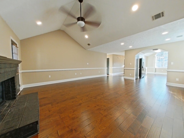 unfurnished living room with lofted ceiling, a brick fireplace, dark hardwood / wood-style floors, and ceiling fan