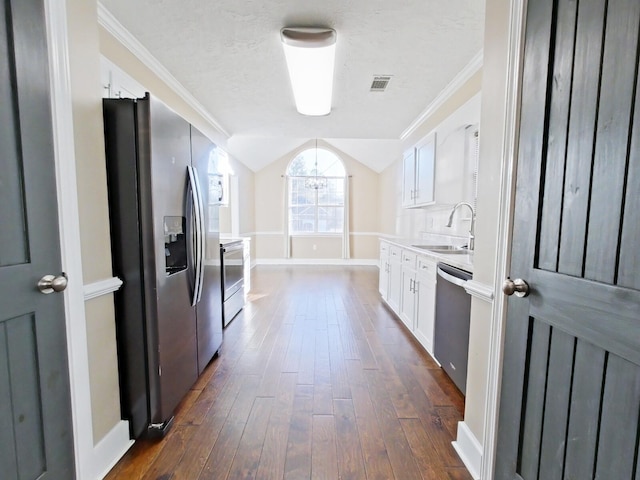 kitchen featuring lofted ceiling, crown molding, stainless steel appliances, white cabinets, and dark hardwood / wood-style flooring