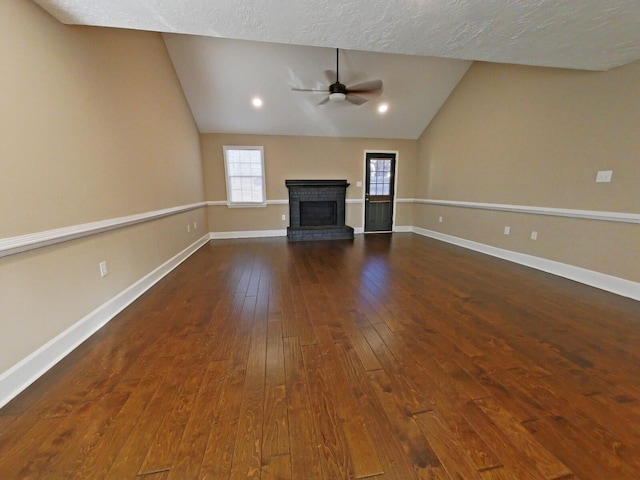 unfurnished living room with ceiling fan, a fireplace, dark hardwood / wood-style flooring, and vaulted ceiling