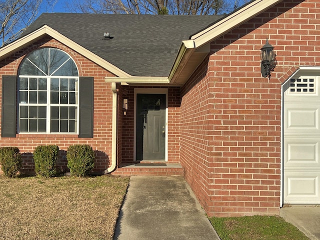 view of exterior entry with a yard