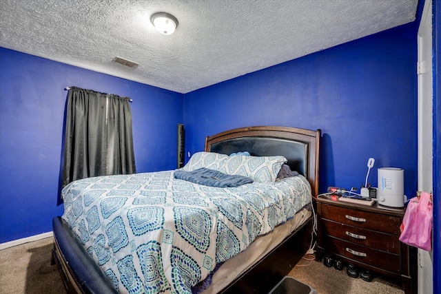 bedroom with a textured ceiling and carpet flooring