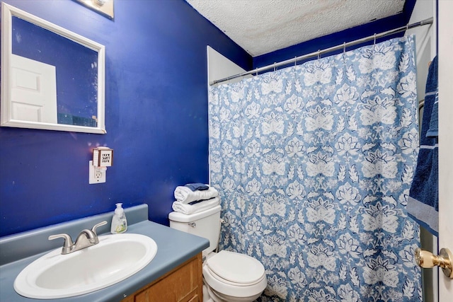 bathroom featuring a textured ceiling, toilet, vanity, and a shower with curtain