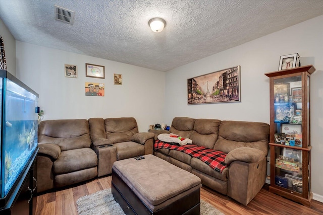 living room with wood-type flooring and a textured ceiling