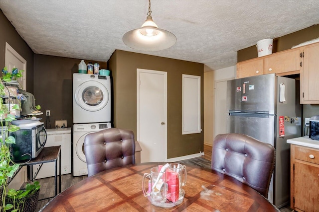 dining area with stacked washer / dryer and a textured ceiling